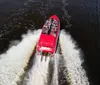 A group of people wearing life vests are enjoying a thrilling boat ride as water splashes around them
