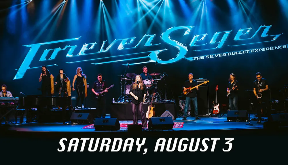 A band performs on stage under a large lit sign that says Forever Seger - The Silver Bullet Experience with a date of Saturday August 3 indicated below