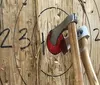 Two people are engaged in axe throwing aiming at wooden targets with marked scoring zones