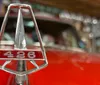 The image shows two scenes on the left a person is using a VR headset at an event called Interactive Experience Unleashed and on the right there is a close-up of a classic car hood ornament with rows of vintage cars in the background at Wheels of Yesteryear