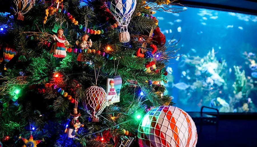 A Christmas tree decorated with festive ornaments and lights is set against a background resembling an underwater scene.