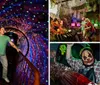 A person stands on a bridge inside a dazzling tunnel-like space with walls covered in colorful luminous patterns