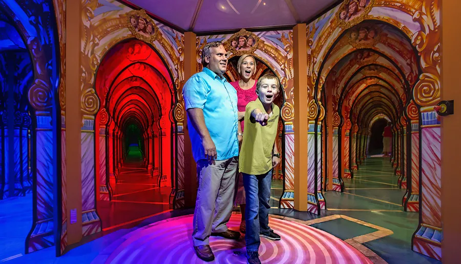 A family is enjoying a colorful mirror maze with intricate, ornate arch designs.