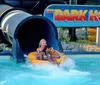 A person is seen emerging with a splash from a water slide at a water park