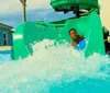 A person is seen emerging with a splash from a water slide at a water park