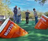 People are enjoying a ride in go-karts on a sunny day at a track