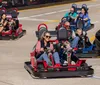 People are enjoying a ride in go-karts on a sunny day at a track