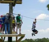 A person wearing a red helmet and a harness is enthusiastically zip-lining amidst green foliage