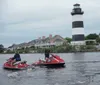 Two people are riding a jet ski with water splashing around them as they speed across a lake