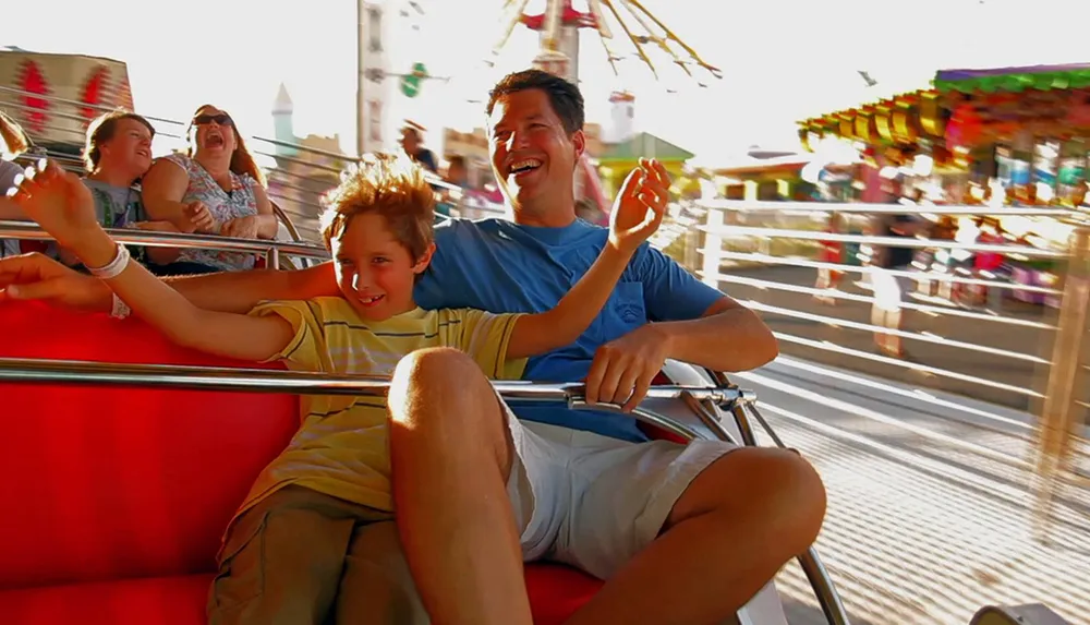 A child and an adult are laughing and enjoying a ride together at an amusement park