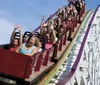 Thrilled passengers raise their hands as they experience the exciting descent on a wooden roller coaster