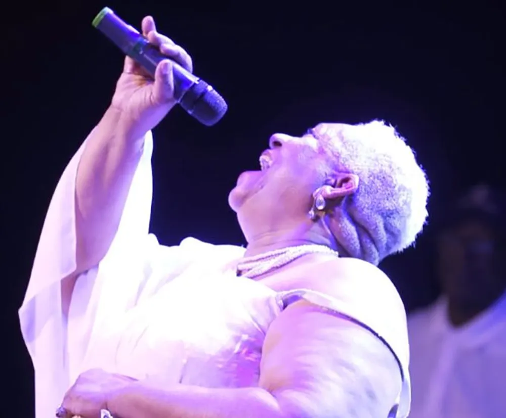 A person with a microphone is passionately singing on stage