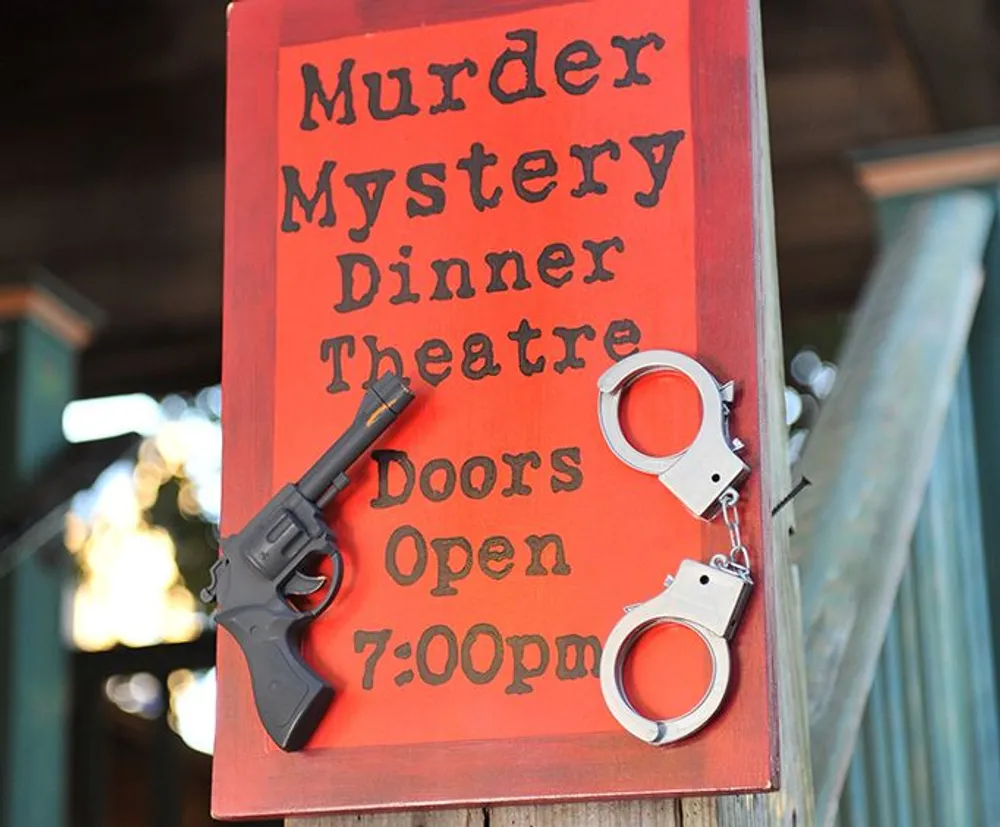 The image shows a red sign for a Murder Mystery Dinner Theatre with the announcement Doors Open 700pm adorned with a toy gun and handcuffs to set the theme