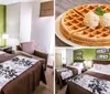 This image shows a tidy hotel room with two double beds each with brown bedspreads and a black and white floral-patterned top sheet flanking a shared nightstand and lamps against a lime green wall with art and a dark wood headboard