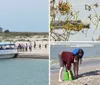 A boat is moored near a narrow strip of sand with people walking around surrounded by water on both sides during what appears to be low tide