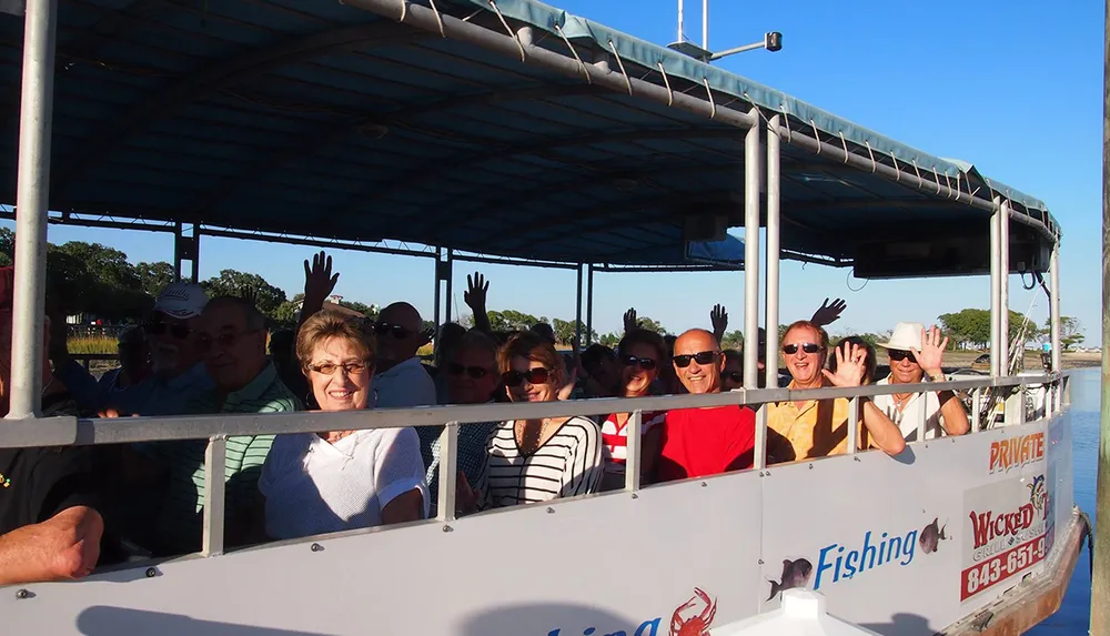 A group of people are smiling and waving from a covered boat suggesting they are on a leisure trip or tour