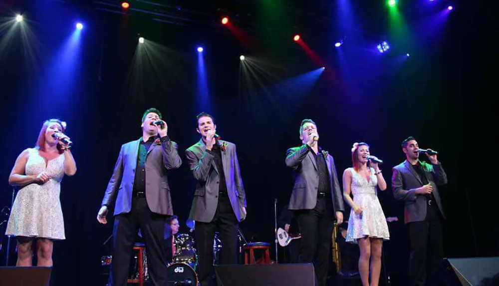 A group of singers perform on stage under colorful stage lighting