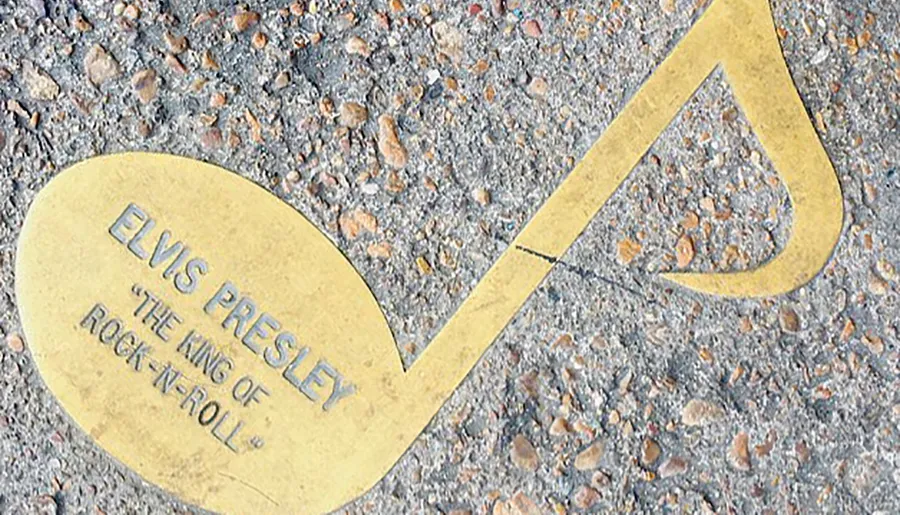 The image shows a golden music note emblem on the ground with an inscription that reads Elvis Presley 'The King of Rock-n-Roll'.