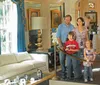 A family of four is observing a well-decorated room with two children wearing audio guides indicating they are likely on an audio-guided tour