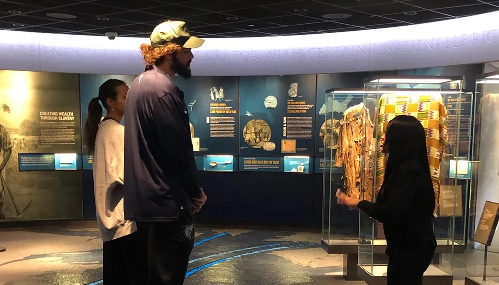 Visitors are engaging with an exhibit at a museum observing displays related to historical topics