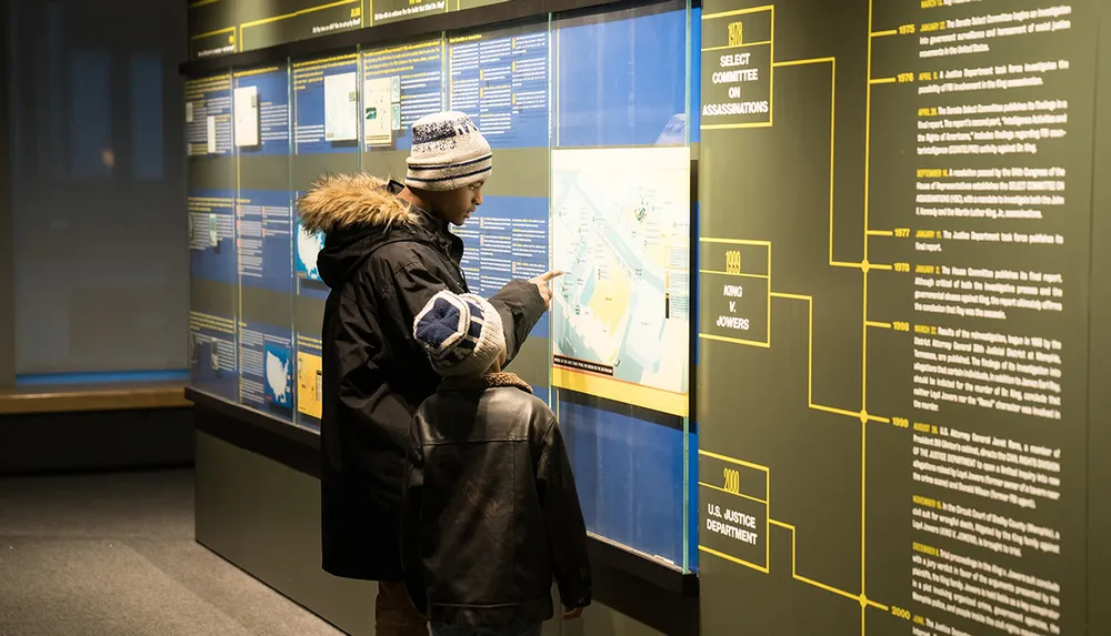 A person is examining an educational display with a timeline and various information panels at a museum or exhibition