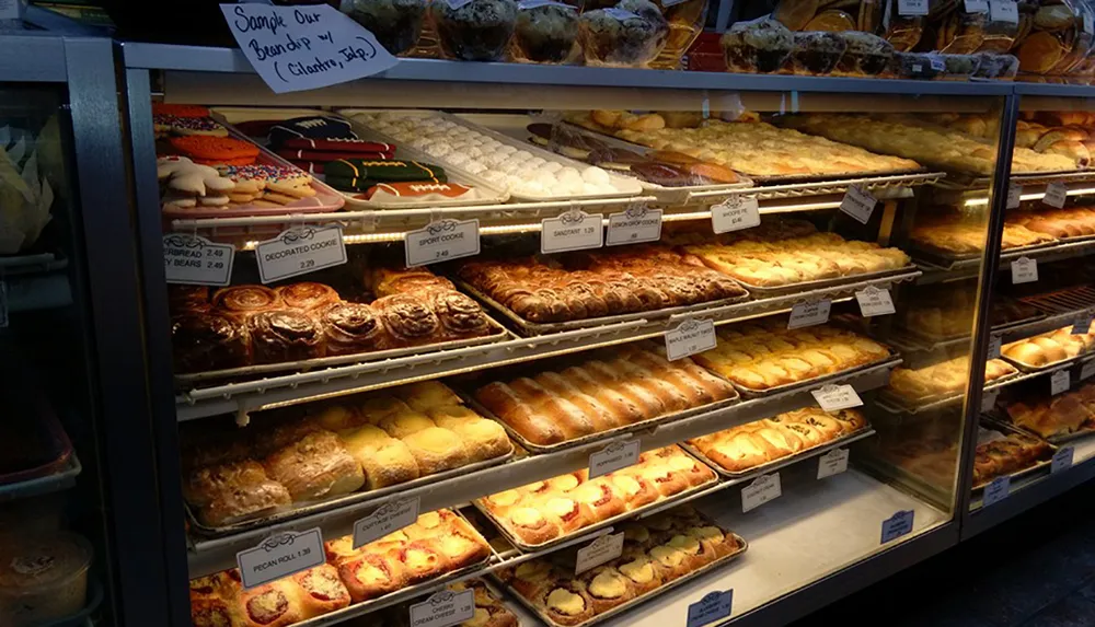 A bakery display case filled with an assortment of sweet and savory pastries each labeled with a price