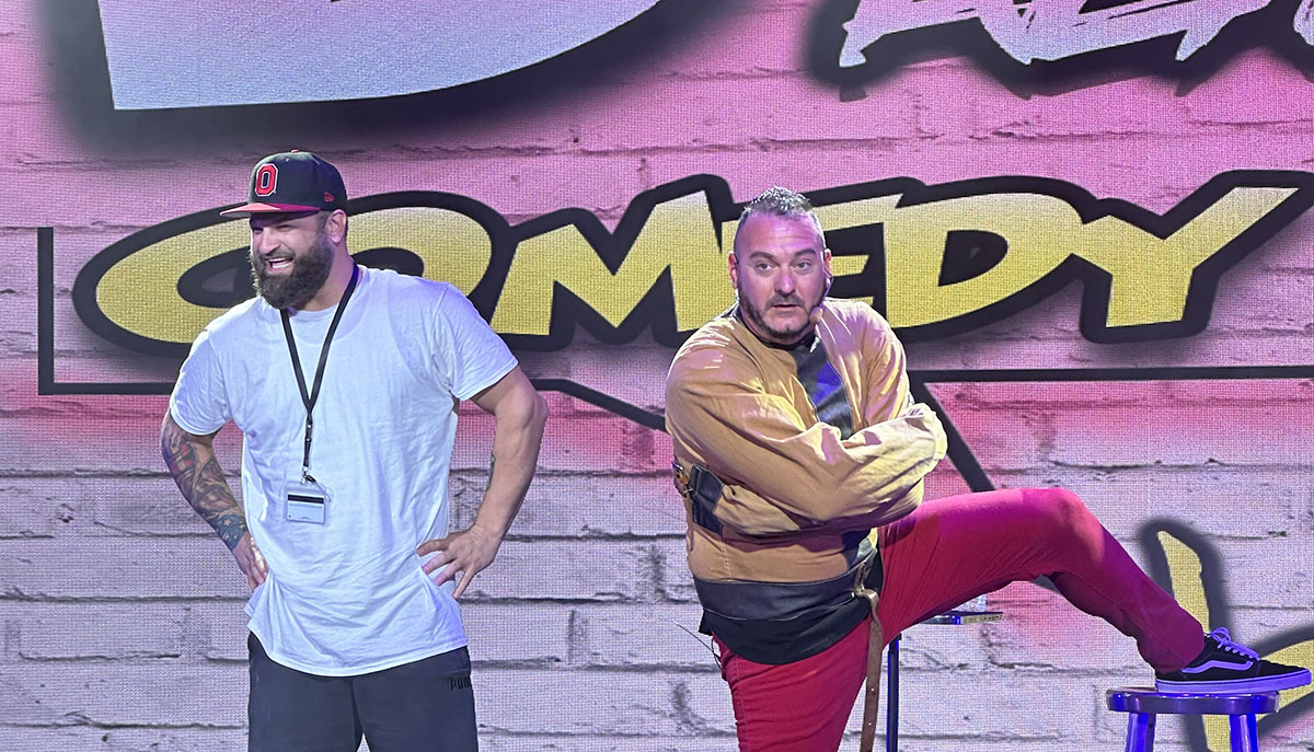 Two men are performing on stage in front of a 